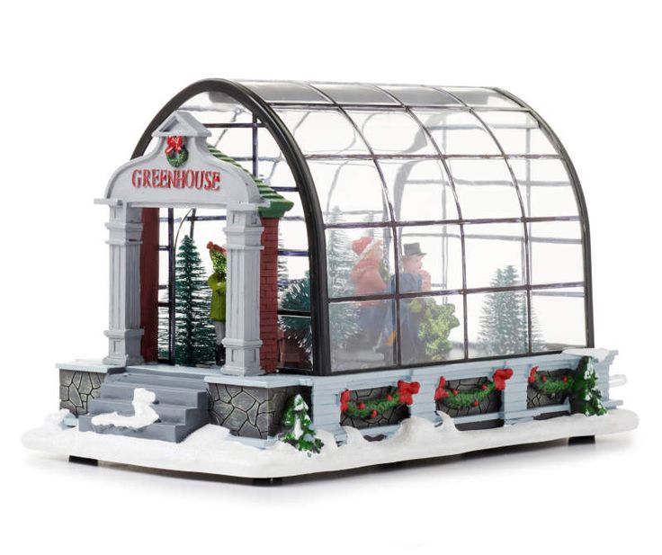 a christmas display in a glass house with snow on the ground