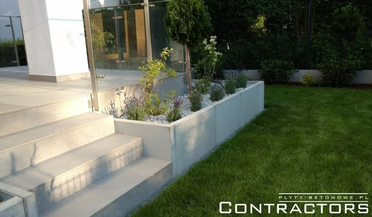 an outdoor garden with steps leading up to the front door and grass area on either side