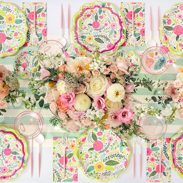 the table is set with flowers and plates