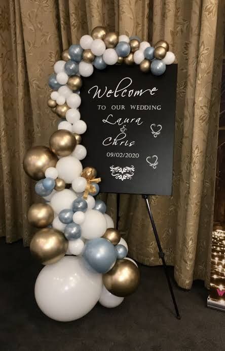 a welcome sign and balloon arch for a wedding