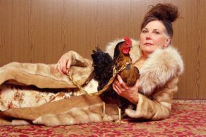 a woman is laying on the floor with two chickens