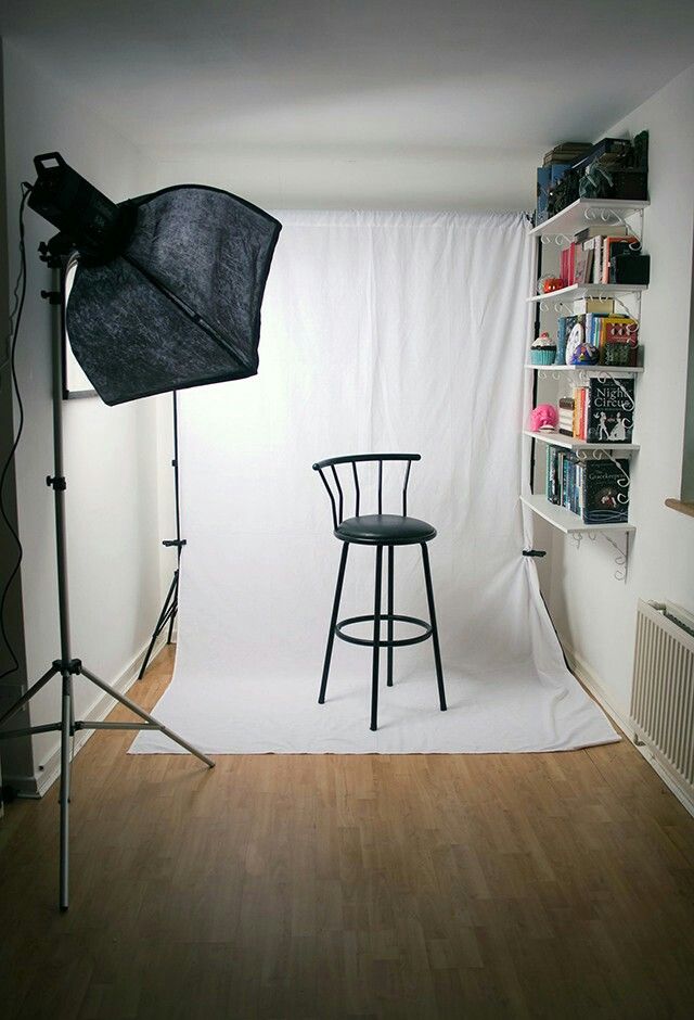 a photo shoot is being set up in a room with white walls and hard wood flooring