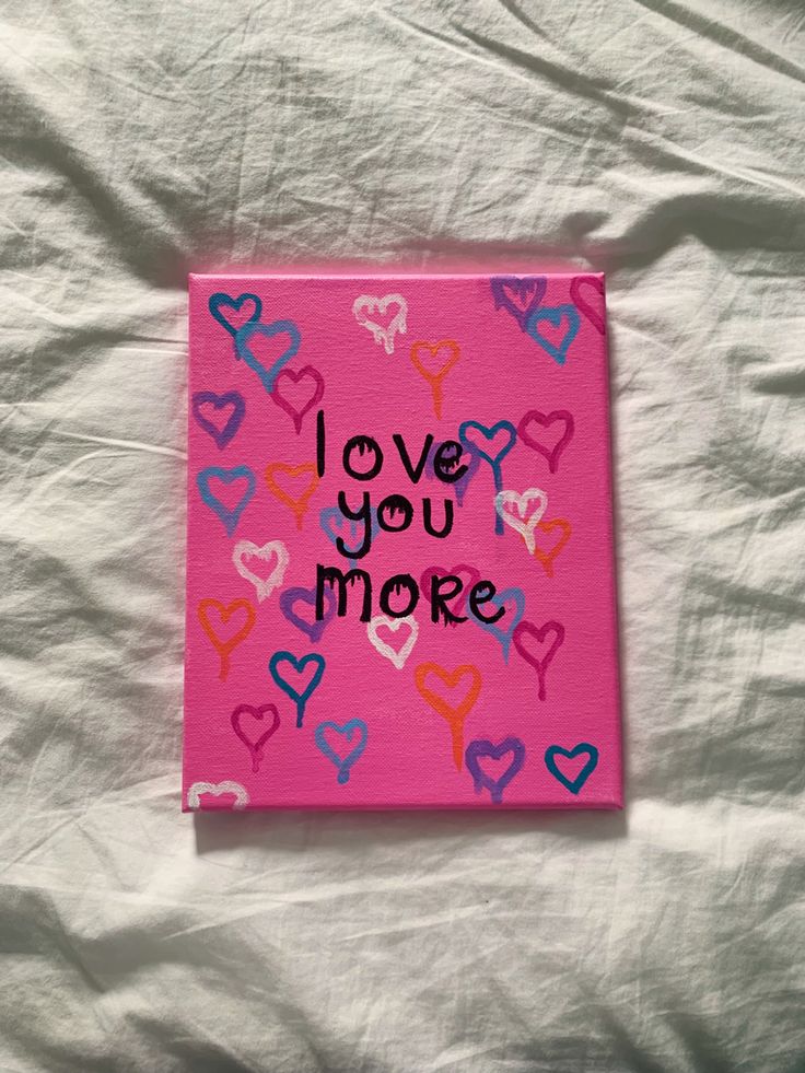 a pink card with hearts and the words love you more written on it