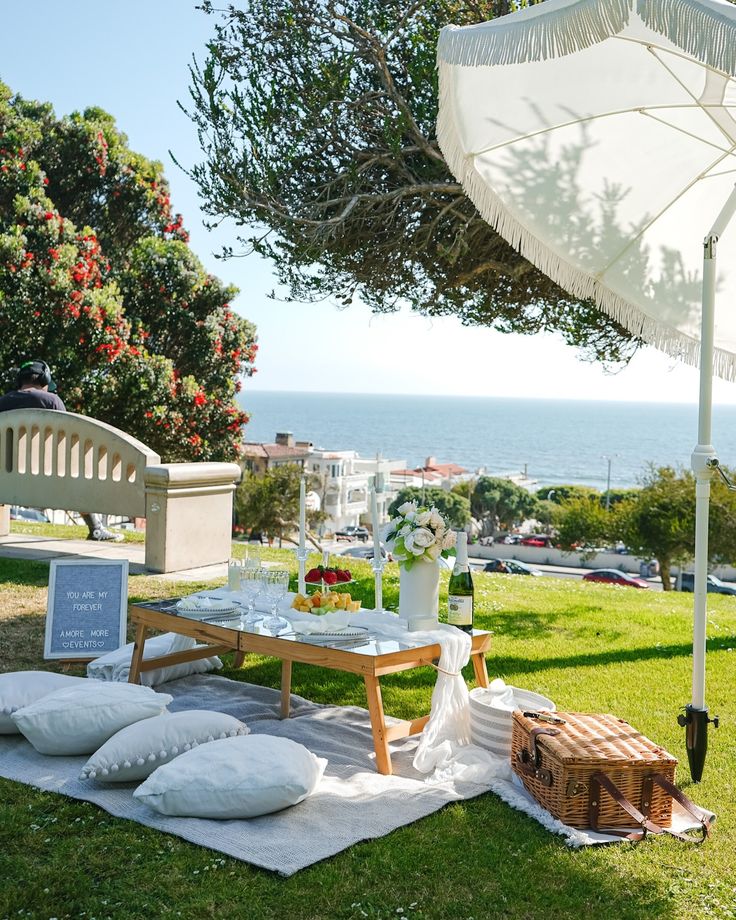 a picnic table set up with pillows and an umbrella