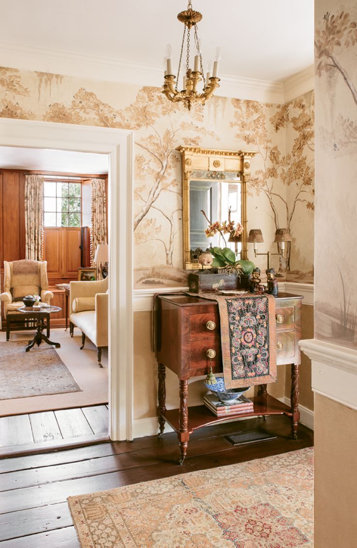 a living room with a chair, table and mirror