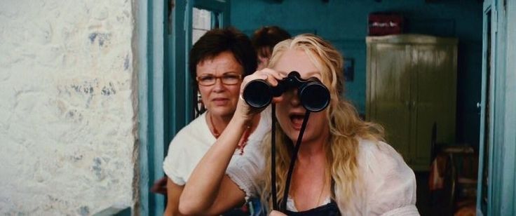 two women are looking through binoculars at something