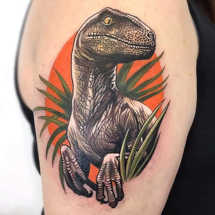 a dinosaur tattoo on the right arm