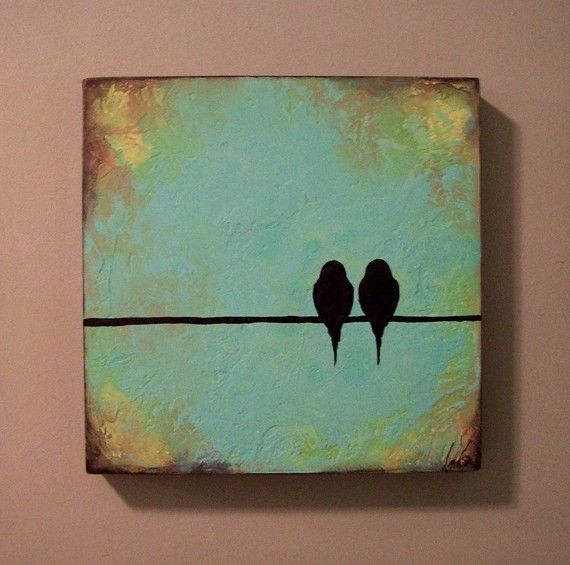 two birds sitting on a wire against a pink wall