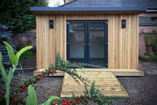 a small wooden building sitting in the middle of a garden