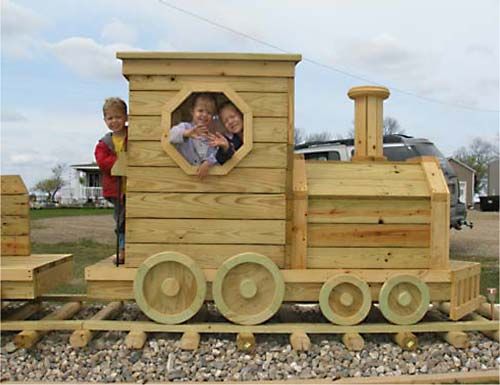 two children are looking out the window of a wooden train