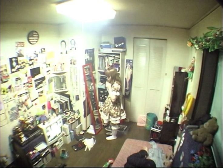 a woman in a room with many items on the walls and shelves full of stuff