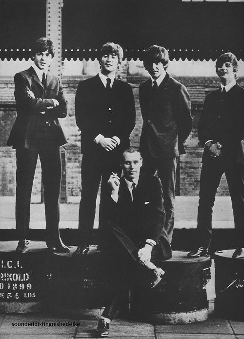 an old black and white photo of four men in suits posing for a group shot