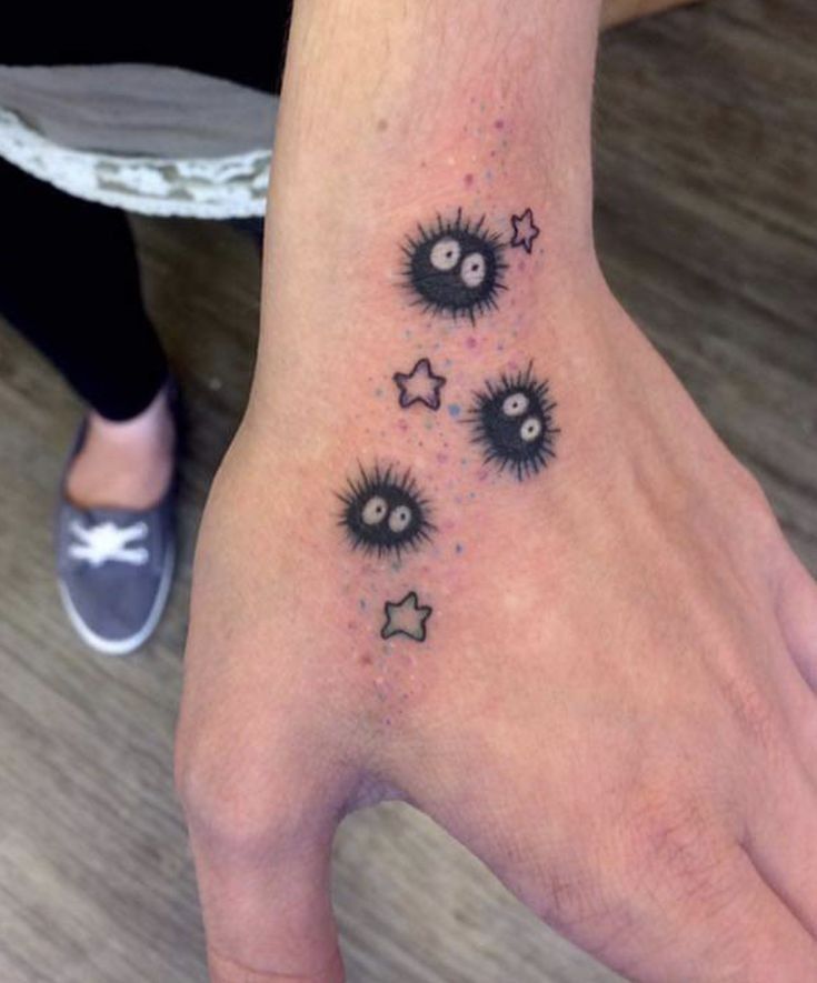 a person's hand with tattoos on it and some stars around the wrist area