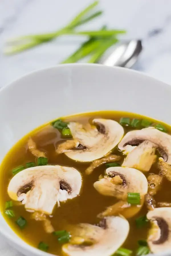 a white bowl filled with mushroom soup on top of a table