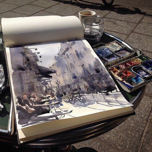 an open book sitting on top of a table next to water bottles and paintbrushes