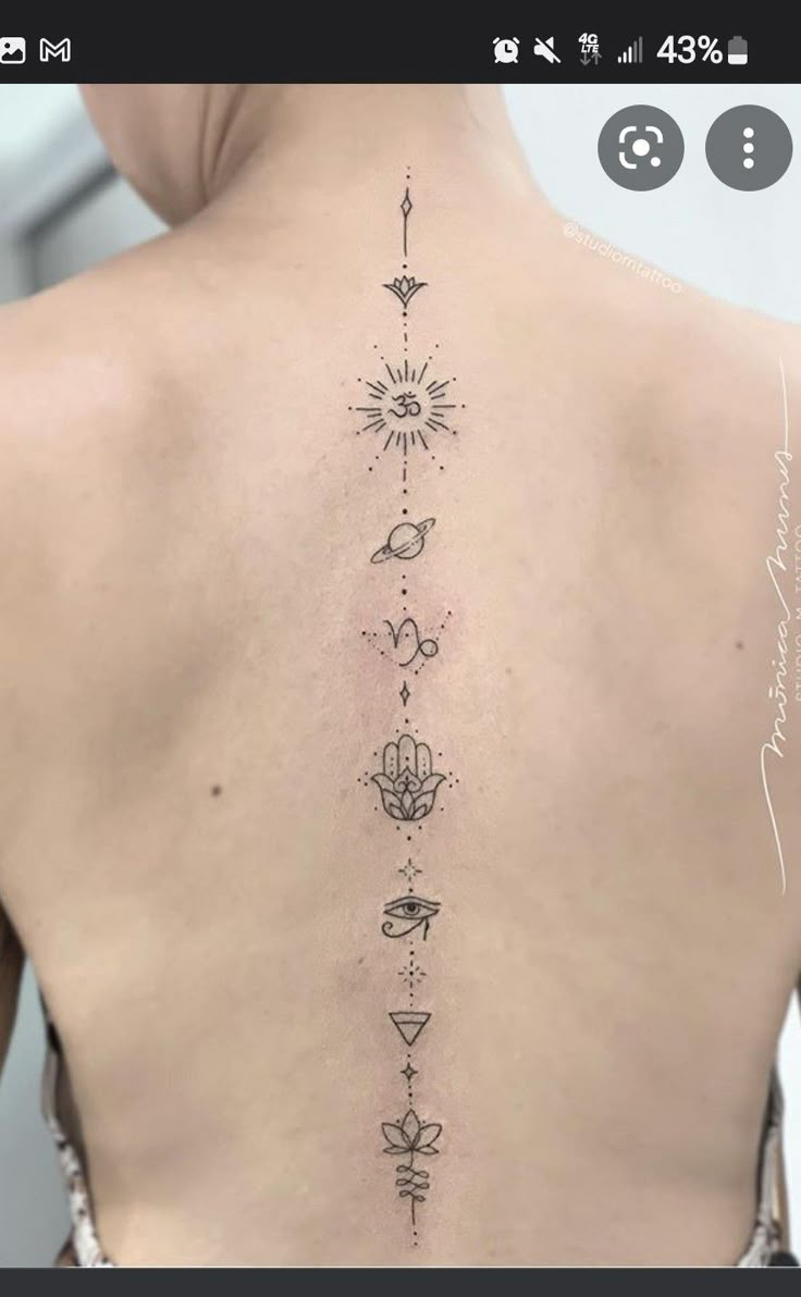 the back of a woman's neck with tattoos on her upper and lower back