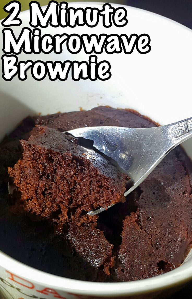 a close up of a bowl of food with a spoon in it and the words 2 minute microwave brownie