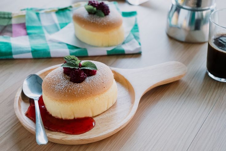 two desserts are sitting on a wooden plate