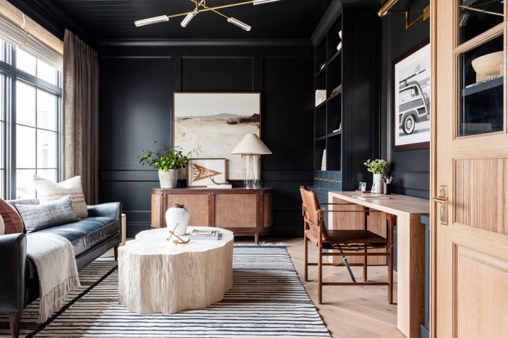 a living room with black walls and furniture