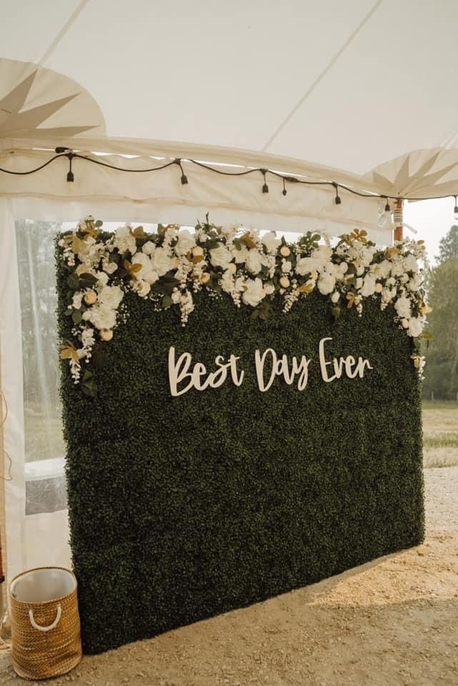 a sign that says best day ever on the side of a wall covered in flowers