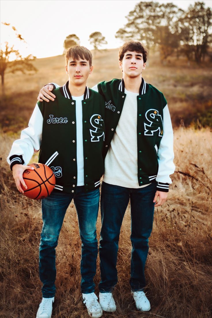 two young men standing next to each other holding a basketball