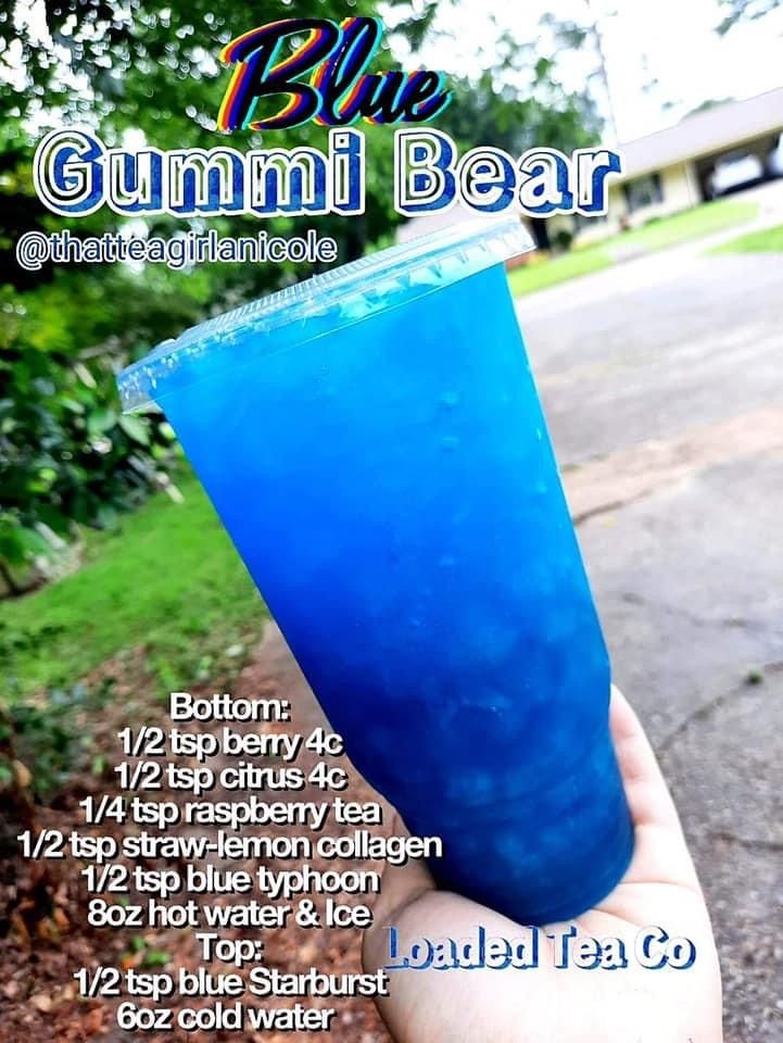 a hand holding up a blue drink in front of a sign that says, blue gummi bear