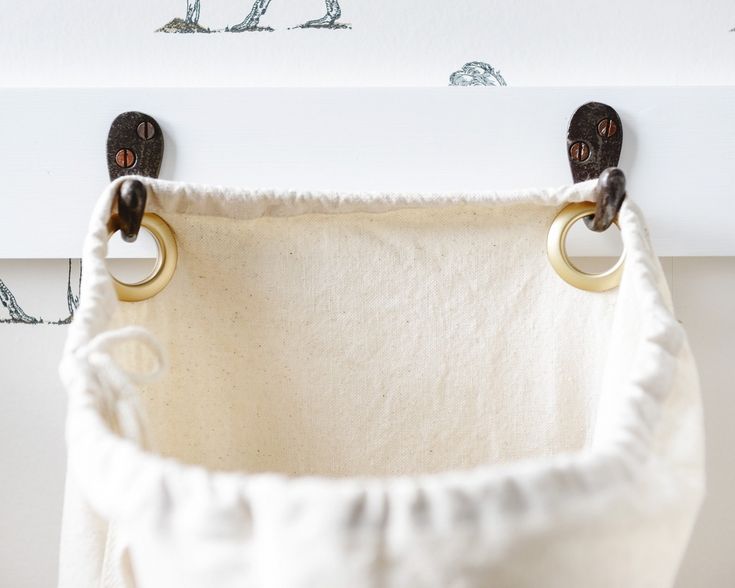 two rings hang from the handles of a white cloth hanging in front of a wall