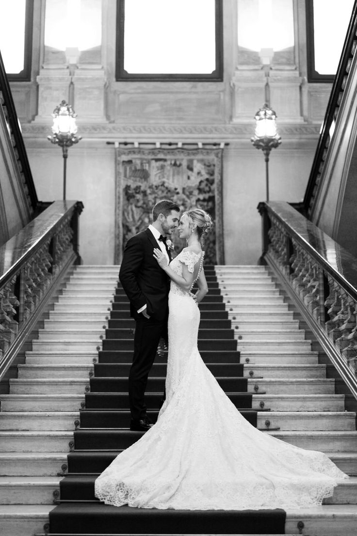 a bride and groom are kissing on the stairs