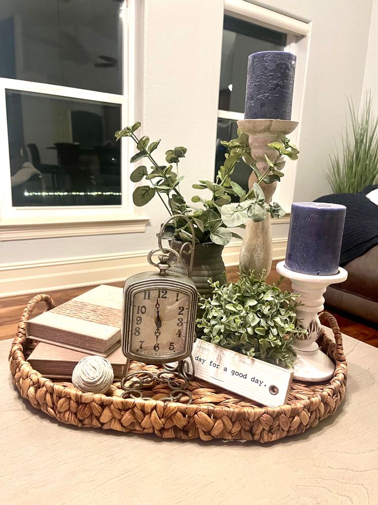 a table with a clock, candles and flowers on it