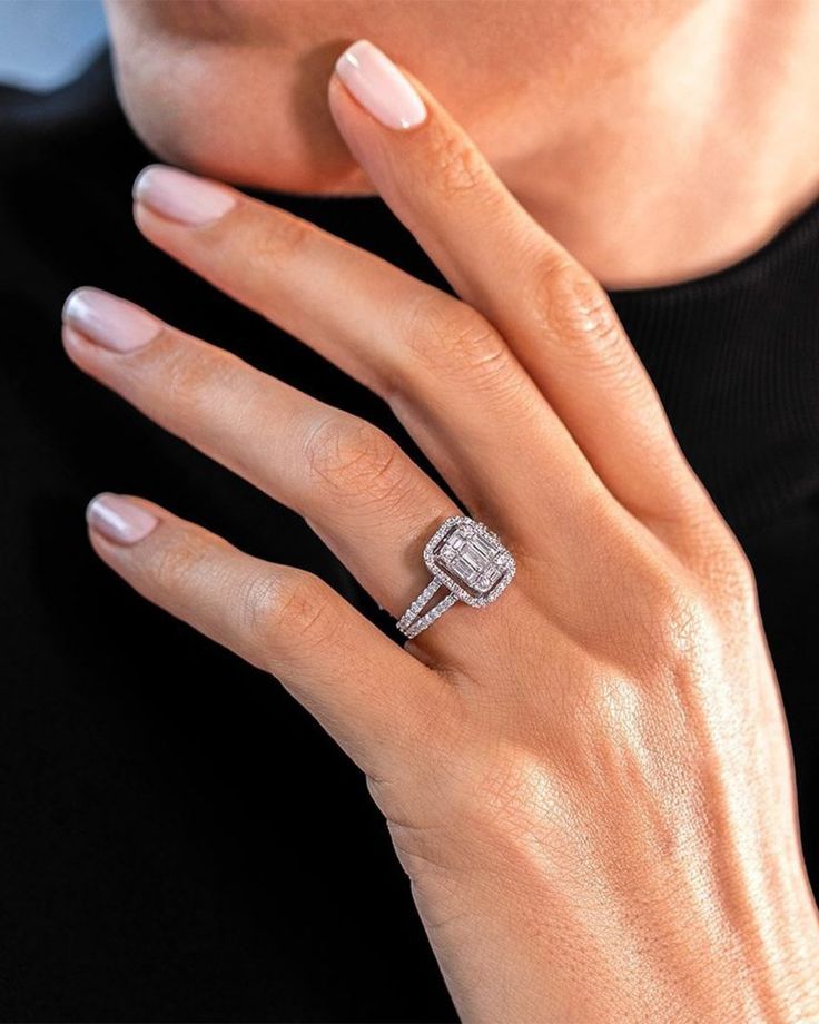 a woman wearing a diamond ring on her finger