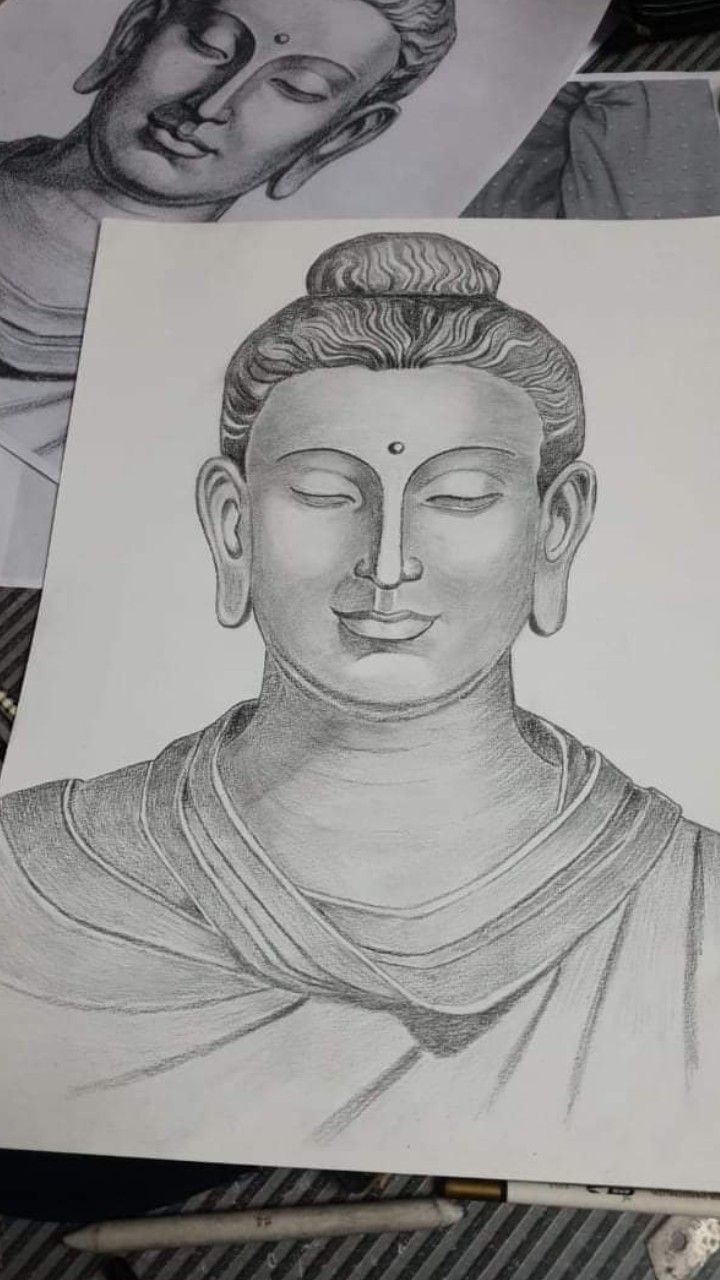 a pencil drawing of a buddha head on top of a piece of paper with other drawings behind it