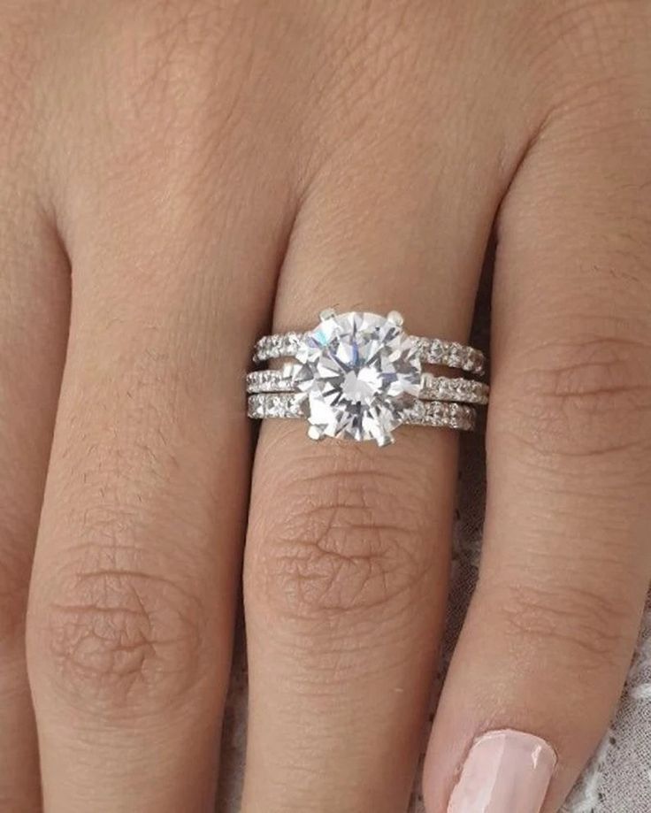 a woman's hand with a ring on it and a diamond in the middle