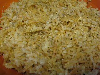 a close up of rice on an orange plate with seasoning sprinkles