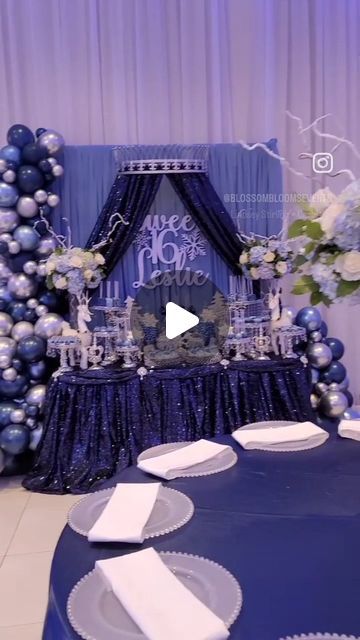 a table set up with blue and silver decorations