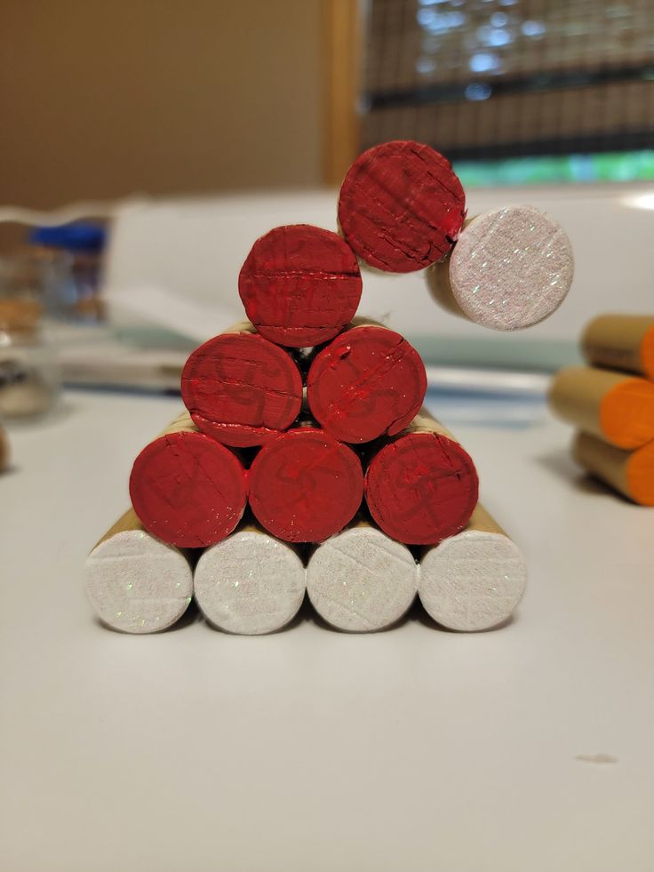 a stack of red, white and orange candy canes sitting on top of each other