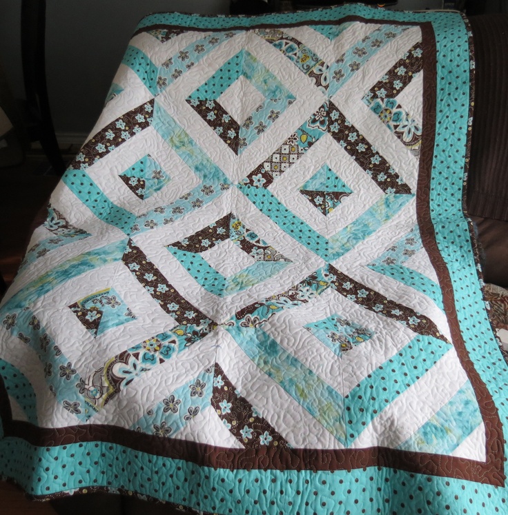 a blue and brown quilt sitting on top of a couch