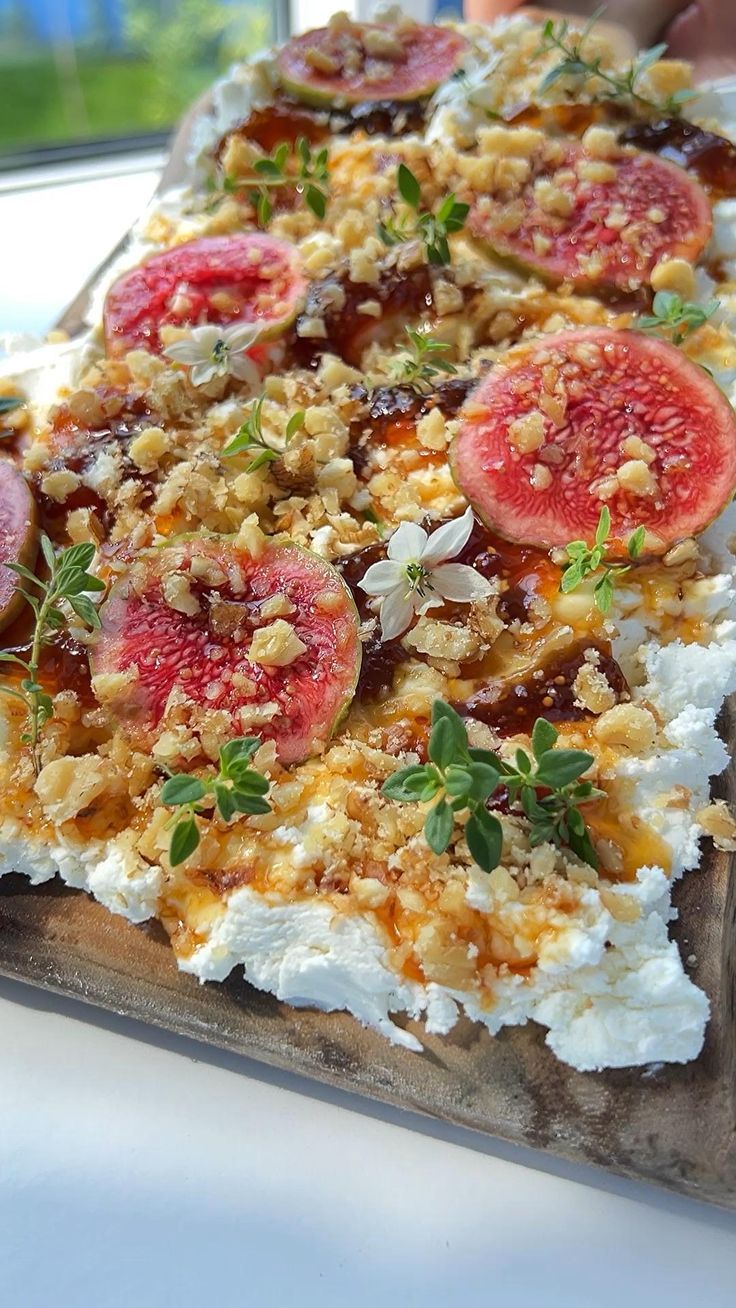 a pizza topped with cheese and toppings sitting on top of a wooden cutting board