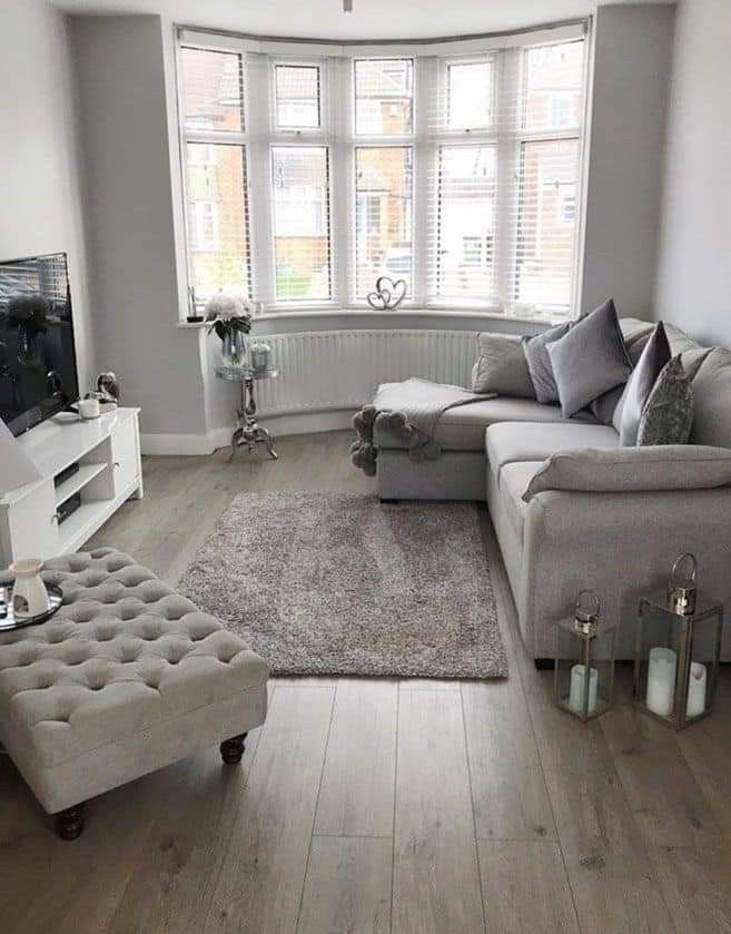 a living room filled with furniture and a flat screen tv on top of a wooden floor