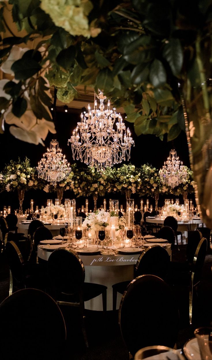 an elegant wedding reception with chandeliers and tables set up for the guests to sit down