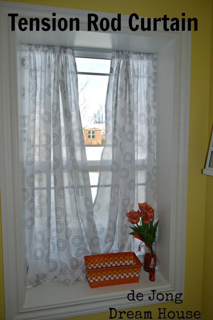 there is a vase with flowers on the window sill in front of the curtains