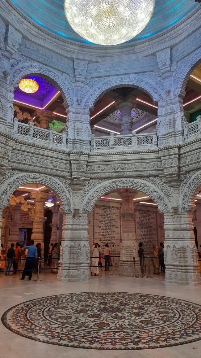 the inside of a building with people standing in it and looking up at the ceiling