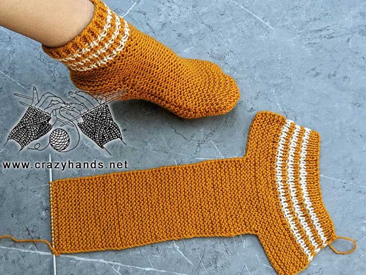 someone is wearing orange socks with white stripes on them and they are knitted from yarn