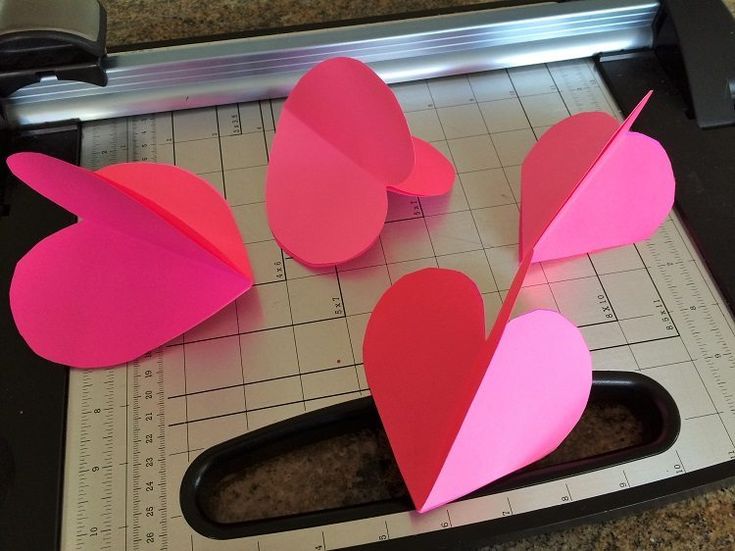 paper hearts cut out on top of a cutting mat for valentine's day crafts