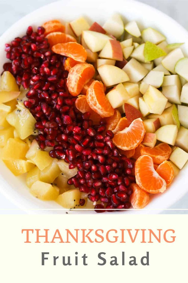 thanksgiving fruit salad with oranges, apples and pomegranate in a white bowl