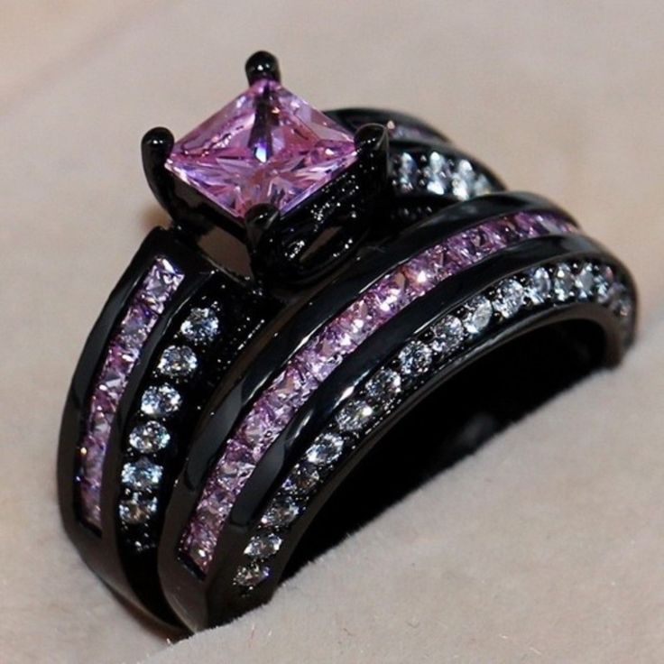 a close up view of a ring with pink and white stones on it's sides