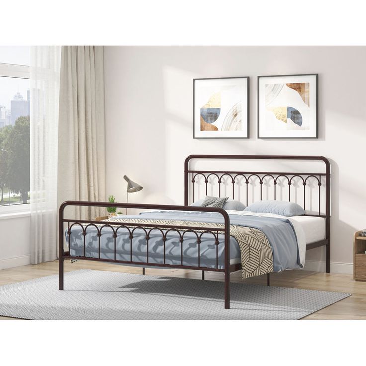 a metal bed frame in a bedroom with two pictures on the wall and a rug