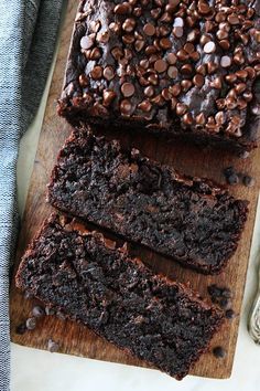 slices of chocolate cake sitting on top of a wooden cutting board