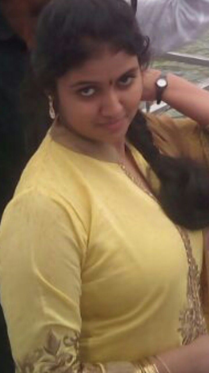 a woman in a yellow sari is posing for the camera with her hand on her shoulder