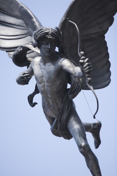 a statue of an angel holding a bow and arrow in its right hand with wings outstretched