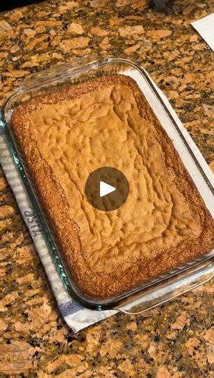 a cake in a pan on top of a counter with a video play button next to it